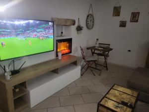 uma sala de estar com uma televisão de ecrã plano e uma lareira em L'edera em Altamura