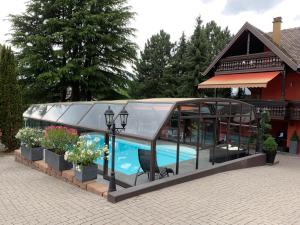 a glass house with a swimming pool in it at Résidence H Logement entier 90m2 Parking privé à 15 min du Marché de Noël in Hoenheim