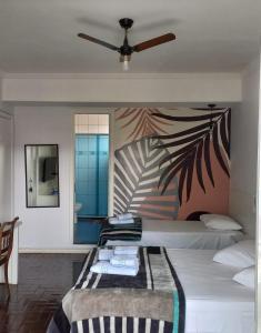 um quarto com uma cama e uma ventoinha de tecto em Pousada Minha Casa em São Lourenço