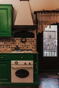 a kitchen with a stove and green cabinets and a window at Monte Pratello - Dimora Rosy in Roccaraso