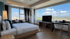a hotel room with a bed and a large window at Aurora Boutique Hotel Imphal in Imphal