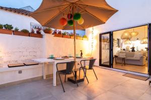 a dining room with a table and an umbrella at Vila Fresca Apartment in Azeitao
