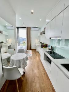 une cuisine avec des armoires blanches et une table et des chaises dans l'établissement Căn hộ Studio Vinhomes Greenbay cho thuê, à Hanoï 9 autres photos
