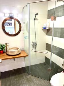 een badkamer met een douche en een glazen deur bij Căn hộ Studio Vinhomes Greenbay cho thuê in Hanoi
