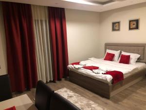 um quarto com uma cama com cortinas vermelhas em As Lux Apartmani Kopaonik em Kopaonik mais 87 fotografias