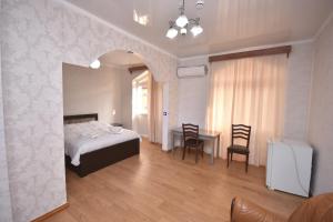 een slaapkamer met een bed en een tafel en stoelen bij HOTEL SAMEGRELO in Zugdidi