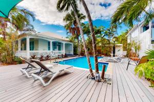 a wooden deck with chairs and a swimming pool at Papa's Hideaway in Key West