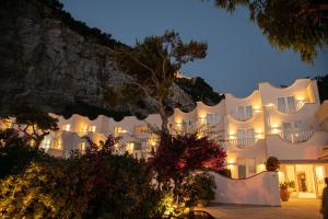 a large white building with lights on it at night at Maya Beach Resort in Massa Lubrense