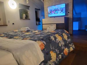 um quarto com uma cama e uma televisão na parede em L'edera em Altamura