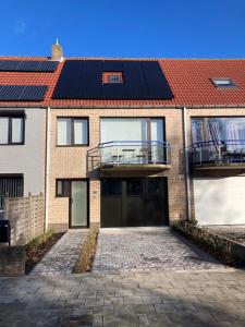 a house with solar panels on the roof at Vakantieappartement DE SPUIKOM in Ostend