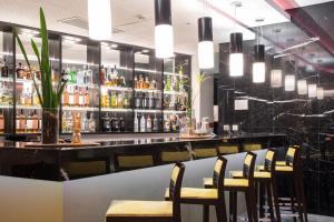 a bar with chairs and a counter with alcohol bottles at SANA Capitol Hotel in Lisbon
