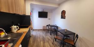 una cucina e una sala da pranzo con due tavoli e una TV a parete di Casa Borges a Charneca
