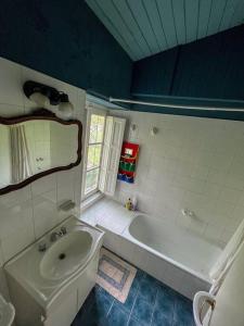 La salle de bains est pourvue d'une baignoire blanche et d'un lavabo. dans l'établissement Casa de montaña en un lugar mágico, à Potrerillos