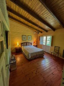 1 dormitorio con 1 cama y suelo de madera en Casa de montaña en un lugar mágico en Potrerillos