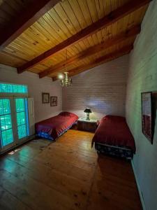 - une chambre avec deux lits et un plafond en bois dans l'établissement Casa de montaña en un lugar mágico, à Potrerillos
