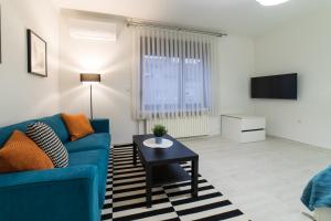 a living room with a blue couch and a table at Angela Luxury Studio Apartment in Zagreb