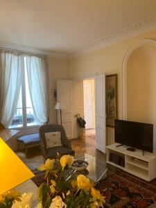 een woonkamer met een flatscreen-tv en een bank bij Appartement Artois in Parijs