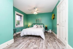 a green bedroom with a bed and a ceiling fan at Chelsea Lake House, Game Room, & Pontoon-rental in Chelsea