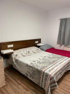 a bedroom with a bed with a blanket on it at Apartamentos el soho in Avila