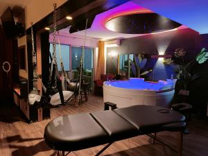 - un bar avec une balançoire dans une pièce dotée d'un éclairage violet dans l'établissement La loveroom bdsm de Nice " la chambre luxe des désirs ", à Nice