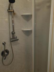 een douche met een glazen deur in de badkamer bij LA CASA DI PUFFY in Selvino