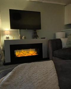 a living room with a fireplace with a tv above it at Ribble Valley Lodge Retreat in Gisburn