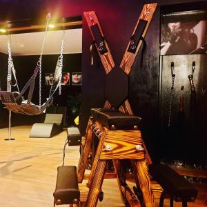 une chambre avec un fauteuil à bascule et des balançoires dans l'établissement La loveroom bdsm de Nice " la chambre luxe des désirs ", à Nice