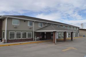 un edificio con un estacionamiento delante de él en Boarders Inn & Suites by Cobblestone Hotels - Broken Bow en Broken Bow