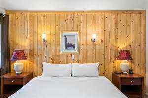 1 dormitorio con 1 cama blanca y 2 lámparas en Indian Creek Lodge, en Douglas City