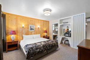 Habitación de hotel con cama, escritorio y escritorio. en Indian Creek Lodge, en Douglas City