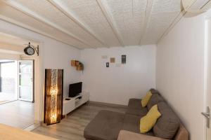 a living room with a couch and a tv at Maison Cosy - Plage 5min - Parc Expo- Arena-Centre ville in Mauguio