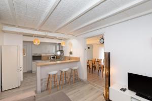 a kitchen with a counter and bar with stools at Maison Cosy - Plage 5min - Parc Expo- Arena-Centre ville in Mauguio