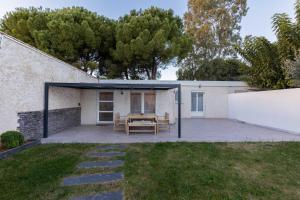 a patio with a table and a fence at Maison Cosy - Plage 5min - Parc Expo- Arena-Centre ville in Mauguio