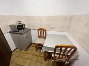 uma pequena cozinha com uma mesa e cadeiras e um micro-ondas em TOKI`S FERIENDOMIZIL em Bad Säckingen