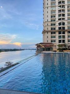 a large swimming pool next to a large building at MyHome @ Riverine Resort Kuching in Kuching