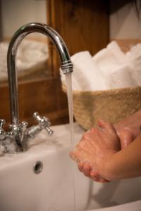 a person is washing their hands under a water faucet at Monte Pratello - Dimora Rosy in Roccaraso