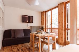 un soggiorno con un tavolo e un divano di [* * *Premium Loft* * *] vista Marmolada ad Alba di Canazei