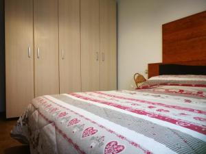 una camera con un letto con una trapunta rossa e bianca. di Sissi House Dolomites a Transacqua