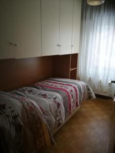una camera da letto con letto, armadi bianchi e finestra di Sissi House Dolomites a Transacqua