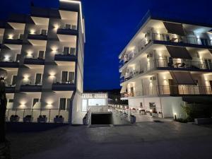 a large white building with its lights on at night at Apartments Mario in Ksamil