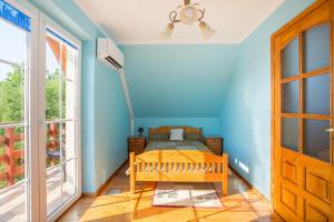 1 dormitorio con cama y pared azul en Domek nad jeziorem, en SzczybaÅ‚y OrÅ‚owskie