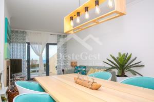 Casa Menezes في لورينها: غرفة طعام مع طاولة خشبية وكراسي زرقاء