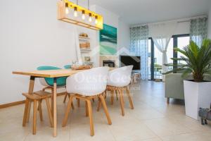 comedor y sala de estar con mesa y sillas en Casa Menezes, en Lourinhã