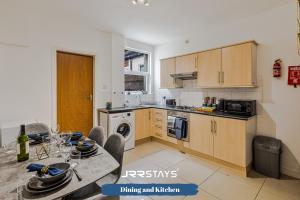 a kitchen with a table and a dining room at Stoke On Trent - 2 Bedroom Sleeps 5, Wi-Fi, Garden - JRR Stays in Etruria