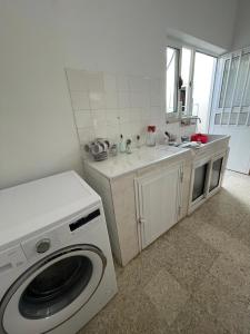 cocina con lavadora y fregadero en Grandmother's House en Famagusta