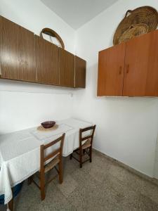 une cuisine avec une table, des chaises et des armoires dans l'établissement Grandmother's House, à Famagouste