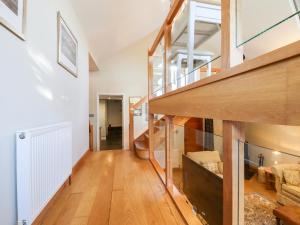 a large living room with wooden floors and stairs at Tillingham View in Rye