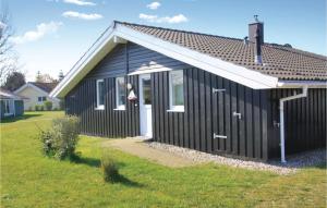 una casa bianca e nera con un prato di Strandpark 21 a Schönhagen
