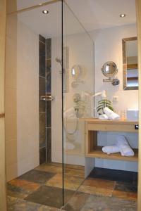 a shower with a glass door in a bathroom at Pension Alpenperle in Holzgau