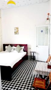 a bedroom with a bed and a black and white checkered floor at Homestay Chez Moi in Can Tho